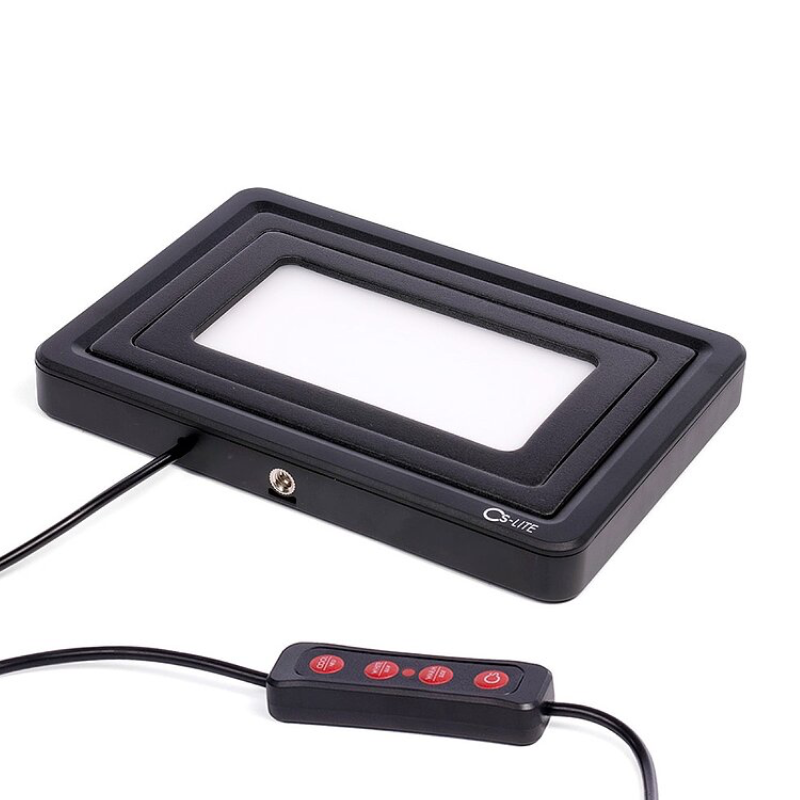 Cinestill CS-LITE with film format masks stacked and wired remote control showing brightness adjustment buttons