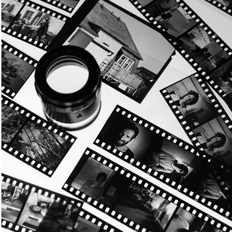 Developed ADOX Scala 50 black and white reversal slide film strips with loupe showing positive B&W transparencies