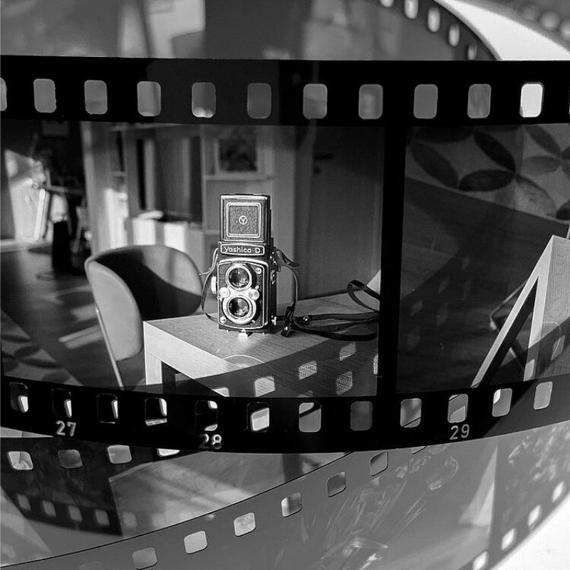 Developed B&W slide film strip processed with ADOX Scala kit showing positive transparency frame of vintage TLR camera