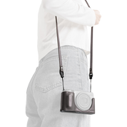 SmallRig quick release leather strap in gray, worn over the shoulder with a camera in a case