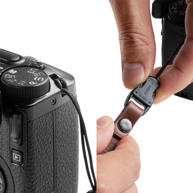 Hand pressing the quick-release buckle of a SmallRig strap on a camera