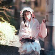 Woman in traditional Japanese kimono sitting outdoors near a stone lantern shot with Pro100 4x5 sheet film