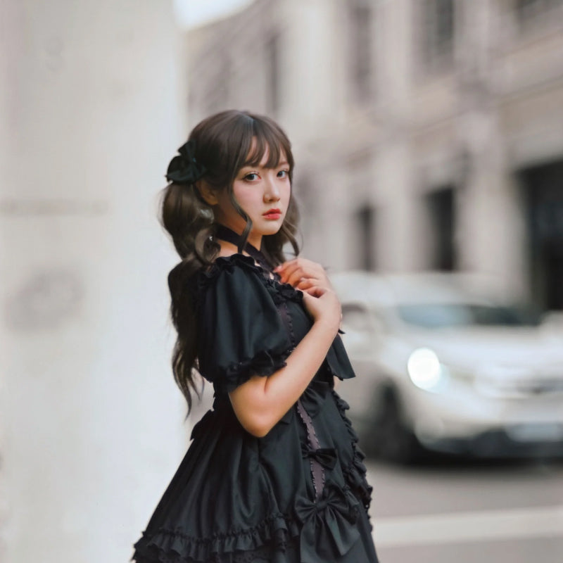 Woman in a black dress standing on a city street with blurred background shot with Pro100 4x5 sheet film