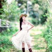 Woman in a white dress and straw hat standing in a lush green forest shot with Pro100 4x5 sheet film