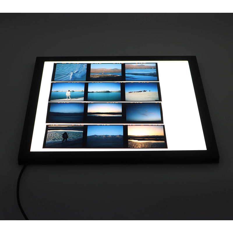Lightbox with multiple small screens displaying various images on a dark background on reflx lab slide viewer light pad